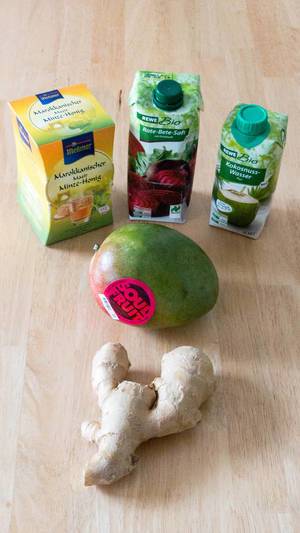 Zutaten für gesunde Ernährung: Ingwer, Mango, Minze-Honig Tee, Rote-Bete-Saft und Kokosnuss-Wasser