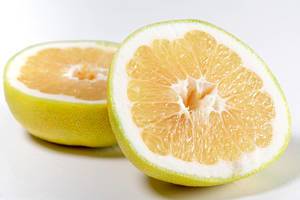 Zwei Hälften einer Zitrone Sweetie Oroblanco auf weißem Hintergrund