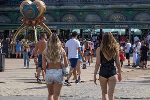 Zwei knapp bekleidete Festivalbesucherinnen gehen auf den Eingang des Tomorrowland 2019 zu