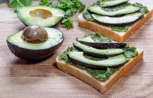 Zwei sandwiches als Konzept für gesunde Ernährung mit frischem Kräuteraufstrich und Avocado