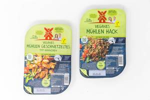 Zwei vegane Produkte auf Basis von Soja von Rügenwalder Mühle: veganes Mühlen Geschnetzeltes (Typ Hähnchen) und veganes Mühlen Hack in Verpackung vor weißem Hintergrund