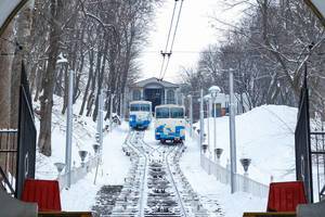 Zwei Zahnradbahnen im verschneiten Kiew mit Blick von unten auf Schienen